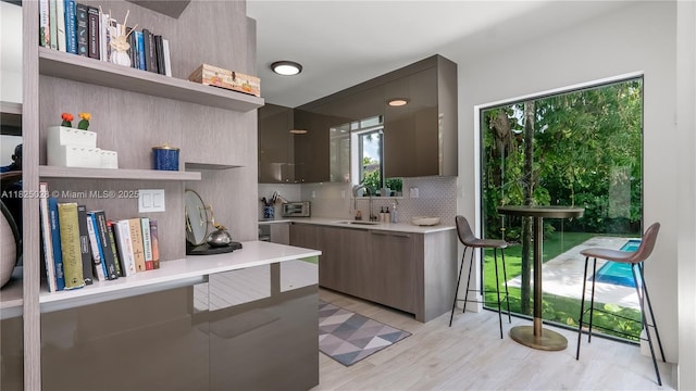 3020 SW 2nd Ave, Miami, FL 33129 - kitchen featuring open shelves, tasteful backsplash, modern cabinets, light countertops, and light wood-style floors