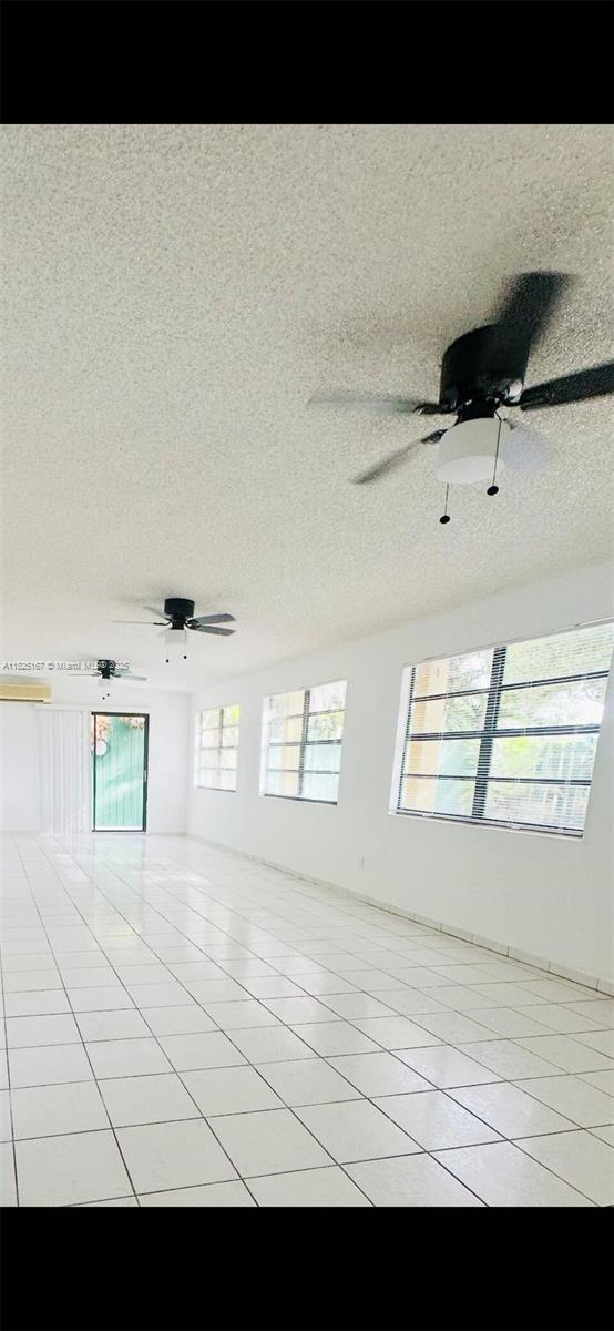 9510 SW 151st Ct, Miami, FL 33196 - spare room with light tile patterned flooring, a textured ceiling, and ceiling fan
