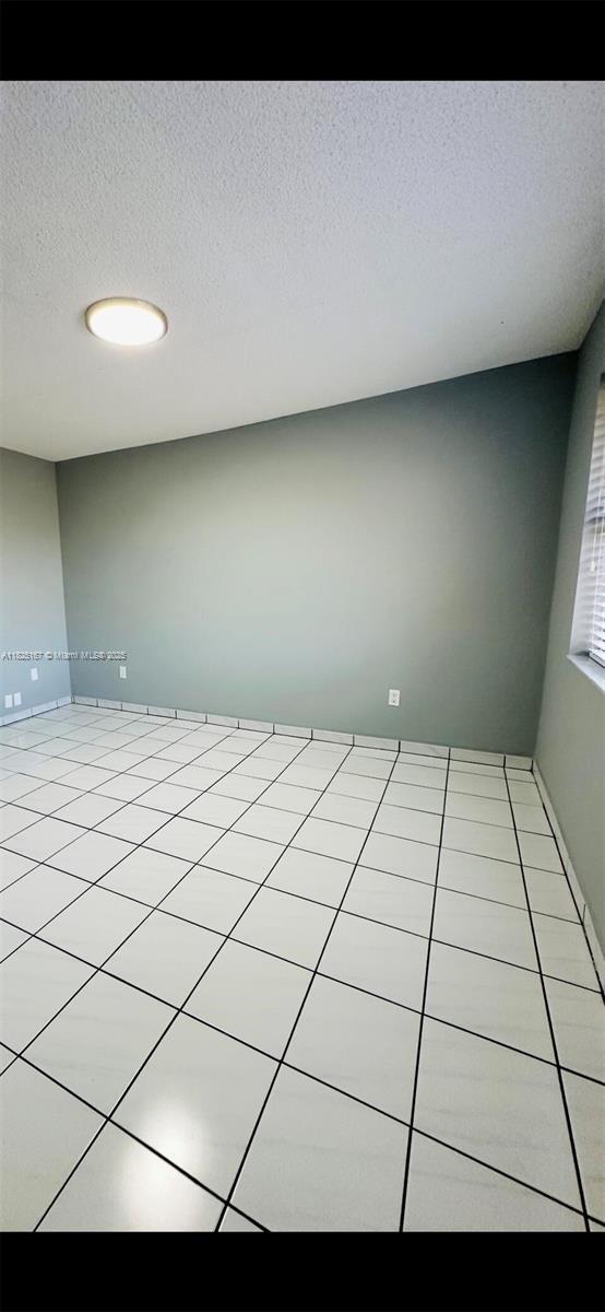 9510 SW 151st Ct, Miami, FL 33196 - spare room with a textured ceiling and light tile patterned floors