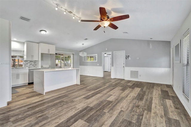 509 SW Hamburg Ter, Port St Lucie, FL 34984 - kitchen featuring stainless steel dishwasher, vaulted ceiling, a ceiling fan, light countertops, and a wainscoted wall