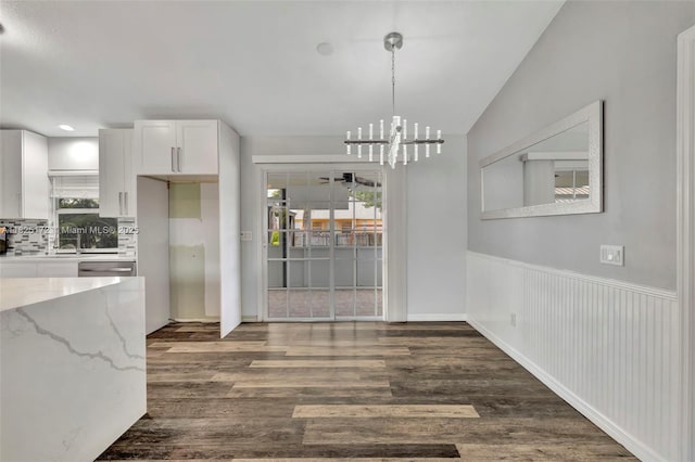509 SW Hamburg Ter, Port St Lucie, FL 34984 - unfurnished dining area with a chandelier, wood finished floors, and healthy amount of natural light