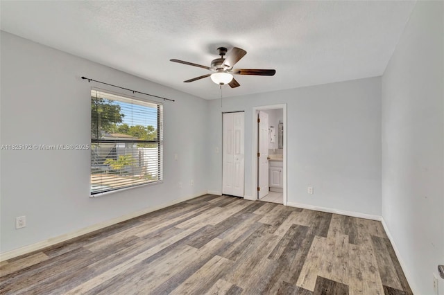509 SW Hamburg Ter, Port St Lucie, FL 34984 - unfurnished bedroom featuring wood finished floors, ensuite bathroom, and ceiling fan