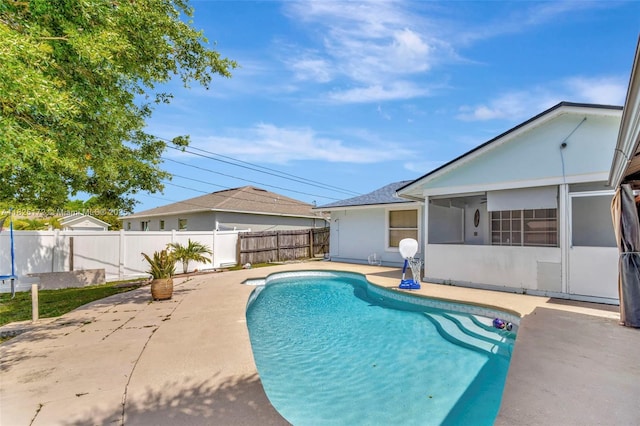 509 SW Hamburg Ter, Port St Lucie, FL 34984 - view of swimming pool featuring a patio area, a fenced backyard, and a sunroom