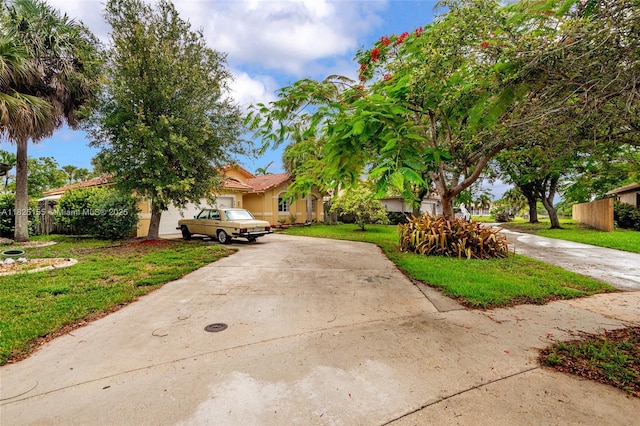 16859 Crestview Ln, Weston, FL 33326 - obstructed view of property with driveway, an attached garage, a front yard, and stucco siding