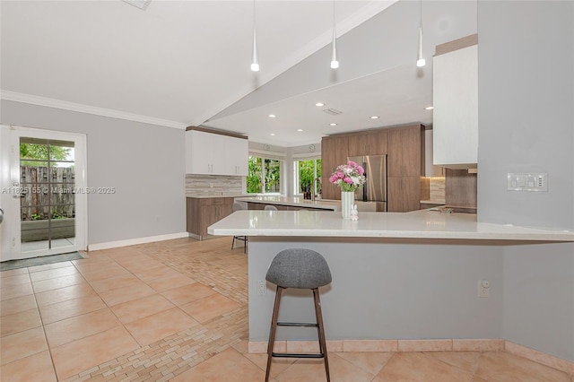 16859 Crestview Ln, Weston, FL 33326 - kitchen with freestanding refrigerator, backsplash, light countertops, a peninsula, and light tile patterned floors
