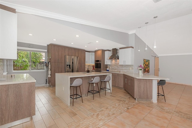 16859 Crestview Ln, Weston, FL 33326 - kitchen with appliances with stainless steel finishes, a breakfast bar area, wall chimney exhaust hood, decorative backsplash, and crown molding