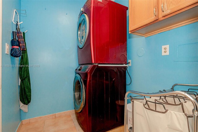 16859 Crestview Ln, Weston, FL 33326 - washroom with stacked washing machine and dryer, cabinet space, and light tile patterned flooring