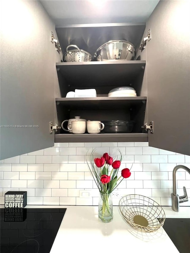 227 NE 2nd St Unit 2713, Miami, FL 33132 - kitchen view of backsplash, black electric stovetop, light countertops, and open shelves
