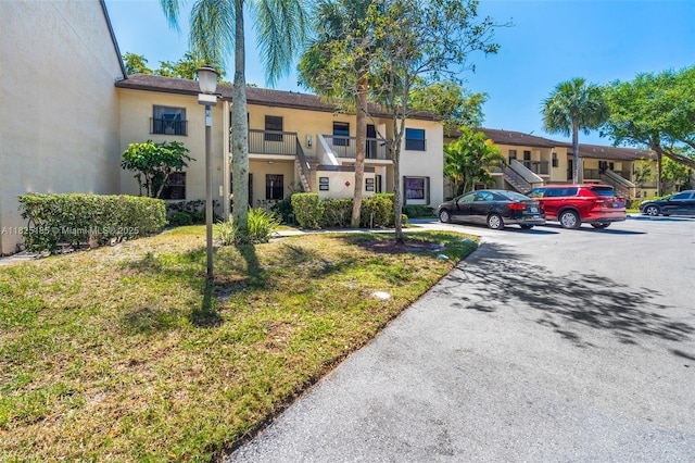 3059 S Carambola Cir S Unit 2330, Coconut Creek, FL 33066 - view of building exterior with uncovered parking, stairway, and a residential view