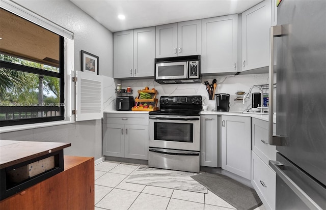 3059 S Carambola Cir S Unit 2330, Coconut Creek, FL 33066 - kitchen featuring appliances with stainless steel finishes, gray cabinetry, light countertops, tasteful backsplash, and recessed lighting