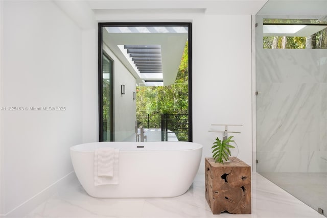 3670 Avocado Ave, Miami, FL 33133 - bathroom with marble tiled floors, a freestanding tub, and healthy amount of natural light