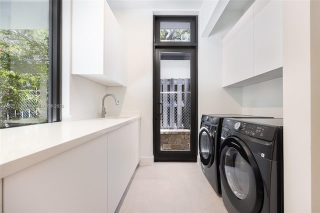 3670 Avocado Ave, Miami, FL 33133 - laundry area with washer and clothes dryer, cabinet space, and light tile patterned floors
