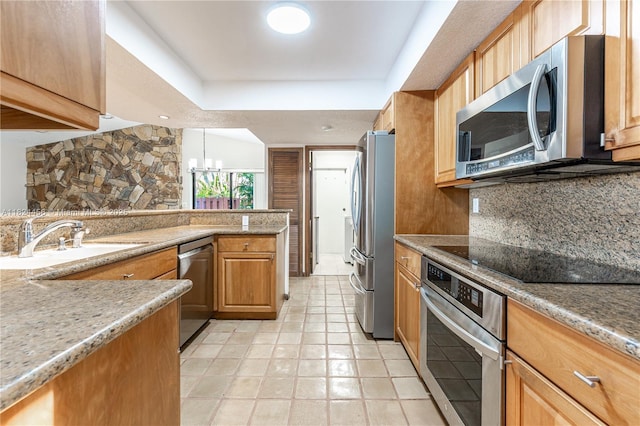 1460 NW 99th Ave, Plantation, FL 33322 - kitchen featuring appliances with stainless steel finishes, backsplash, a chandelier, light stone counters, and a peninsula