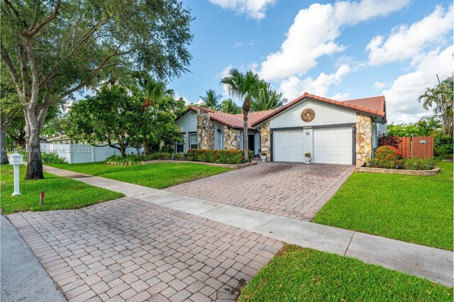 1460 NW 99th Ave, Plantation, FL 33322 - view of front of home with stone siding, an attached garage, decorative driveway, stucco siding, and a tiled roof