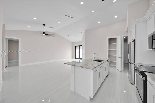 1520 NW 36th Pl, Cape Coral, FL 33993 - kitchen featuring appliances with stainless steel finishes, white cabinetry, a center island with sink, light stone countertops, and ceiling fan