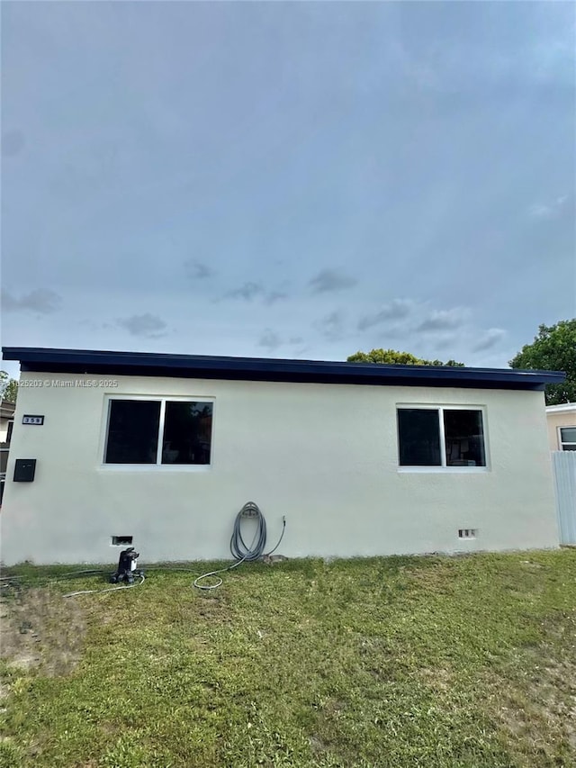 359 E 46th St, Hialeah, FL 33013 - view of side of home with stucco siding and a yard