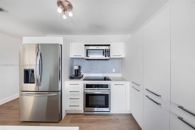 1900 N Bayshore Dr Unit 4111, Miami, FL 33132 - kitchen with stainless steel appliances, white cabinetry, light countertops, and light wood finished floors
