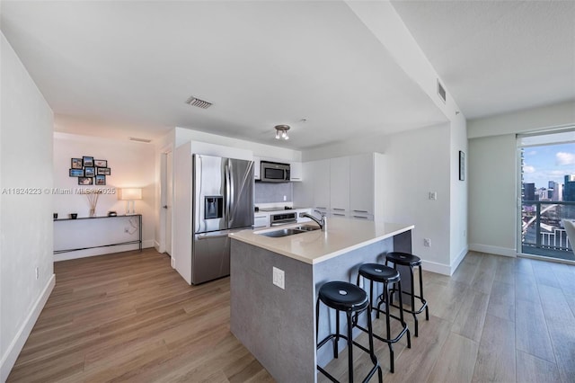 1900 N Bayshore Dr Unit 4111, Miami, FL 33132 - kitchen with stainless steel appliances, light wood-type flooring, a kitchen breakfast bar, and light countertops