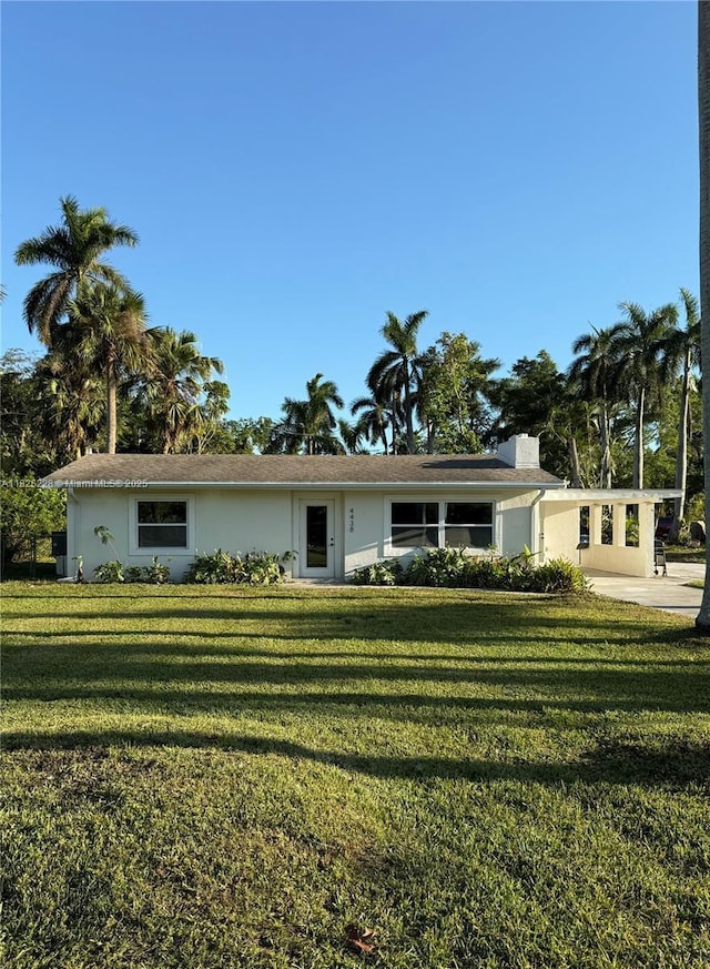 4438 E Riverside Dr, Fort Myers, FL 33905 - single story home with a front lawn, stucco siding, an attached carport, and a chimney