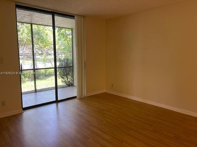 1224 S Military Trl Unit 2312, Deerfield Beach, FL 33442 - spare room featuring floor to ceiling windows and wood finished floors