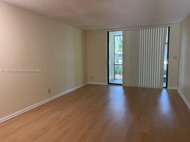 1224 S Military Trl Unit 2312, Deerfield Beach, FL 33442 - spare room featuring wood finished floors, a textured ceiling, and floor to ceiling windows
