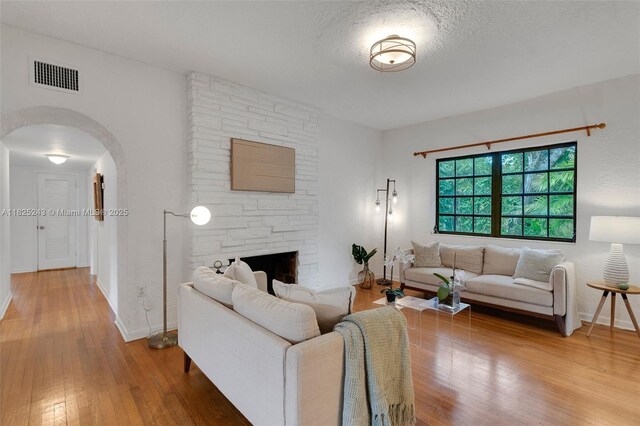 425 Cadagua Ave, Coral Gables, FL 33146 - living room with wood-type flooring, arched walkways, and a fireplace