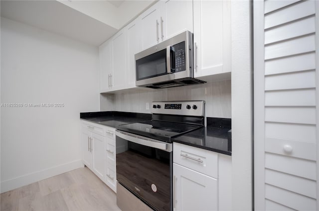 2406 Centergate Dr Unit 202, Miramar, FL 33025 - kitchen featuring stainless steel appliances, tasteful backsplash, white cabinets, light wood-type flooring, and dark stone countertops