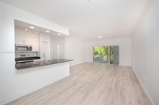 2406 Centergate Dr Unit 202, Miramar, FL 33025 - kitchen with stainless steel microwave, electric range, recessed lighting, open floor plan, and light wood-type flooring