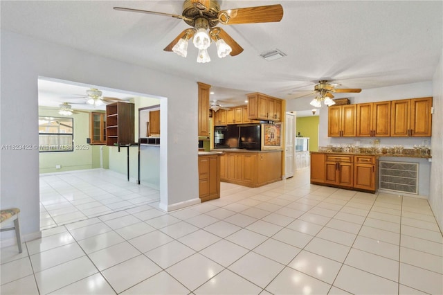 134 E Palm Dr, Margate, FL 33063 - kitchen featuring ceiling fan, brown cabinetry, and light tile patterned floors