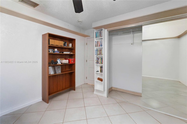 134 E Palm Dr, Margate, FL 33063 - unfurnished bedroom with a textured ceiling, a ceiling fan, light tile patterned flooring, and a closet