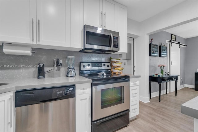 3610 NW 171st St, Miami Gardens, FL 33056 - kitchen featuring appliances with stainless steel finishes, white cabinets, light countertops, and tasteful backsplash