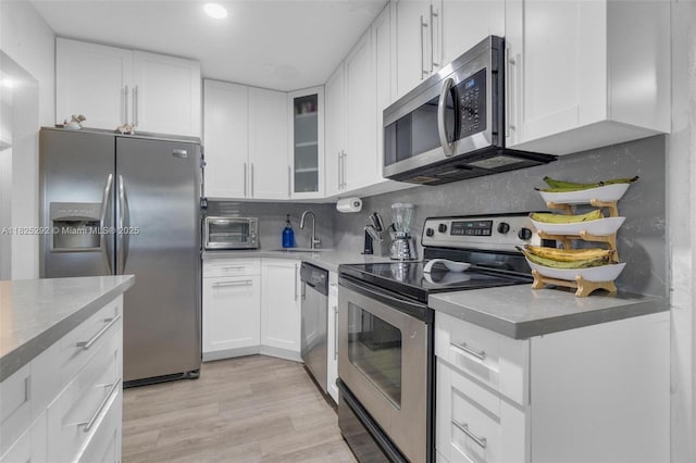 3610 NW 171st St, Miami Gardens, FL 33056 - kitchen featuring appliances with stainless steel finishes, white cabinets, decorative backsplash, glass insert cabinets, and recessed lighting