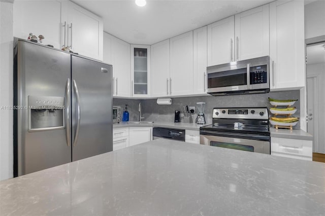 3610 NW 171st St, Miami Gardens, FL 33056 - kitchen featuring stainless steel appliances, white cabinets, glass insert cabinets, and tasteful backsplash