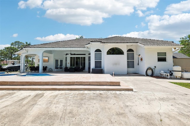 14387 Temple Blvd, Palm Beach, FL 33470 - rear view of property with ceiling fan, a tiled roof, a patio area, an outdoor pool, and outdoor lounge area