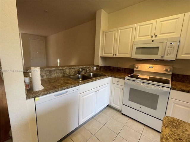 3550 Oleander Ter, Riviera Beach, FL 33404 - kitchen featuring white appliances, light tile patterned floors, dark countertops, and white cabinetry