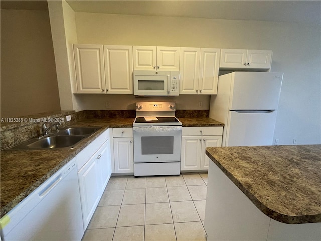 3550 Oleander Ter, Riviera Beach, FL 33404 - kitchen featuring white appliances, dark countertops, and white cabinetry