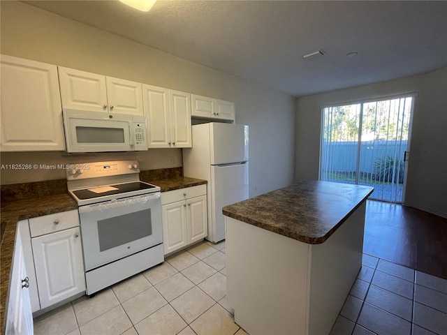 3550 Oleander Ter, Riviera Beach, FL 33404 - kitchen with white appliances, dark countertops, and white cabinetry