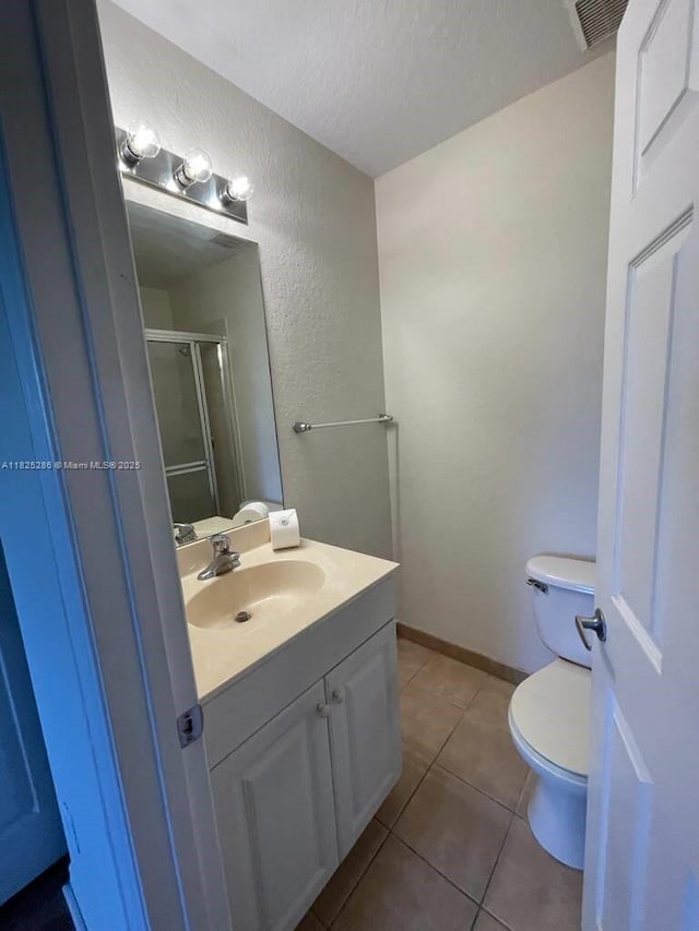 3550 Oleander Ter, Riviera Beach, FL 33404 - bathroom featuring vanity, a textured wall, tile patterned flooring, a shower stall, and a textured ceiling
