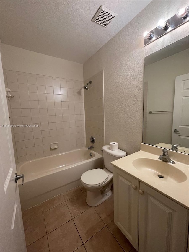 3550 Oleander Ter, Riviera Beach, FL 33404 - bathroom with a textured wall, vanity, washtub / shower combination, a textured ceiling, and tile patterned flooring