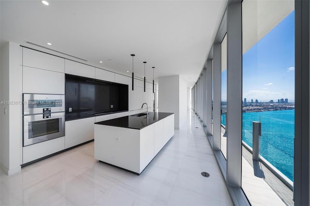 300 Biscayne Blvd Way Unit 4301, Miami, FL 33131 - kitchen with modern cabinets, white cabinetry, dark countertops, an island with sink, and hanging light fixtures