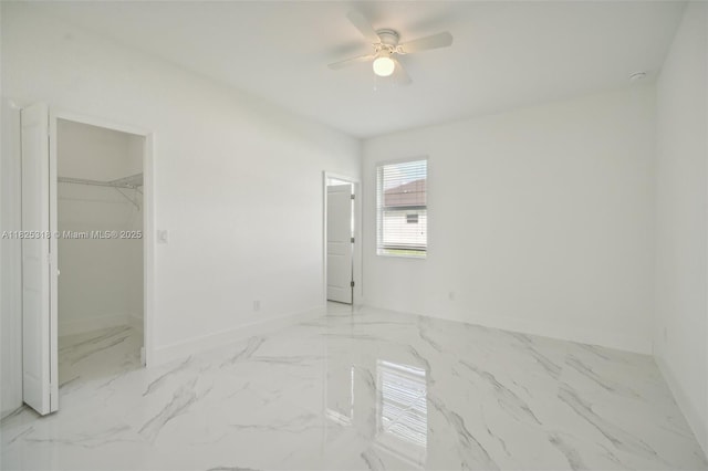 3411 62nd St W, Lehigh Acres, FL 33971 - unfurnished bedroom with marble finish flooring, a spacious closet, and a ceiling fan