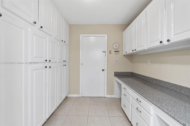 608 Saint Andrews Rd Unit 46, Hollywood, FL 33021 - kitchen featuring a textured ceiling, light tile patterned floors, and white cabinets