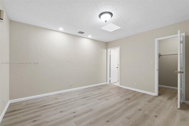 608 Saint Andrews Rd Unit 46, Hollywood, FL 33021 - unfurnished bedroom with light wood-type flooring, a textured ceiling, a walk in closet, recessed lighting, and a closet