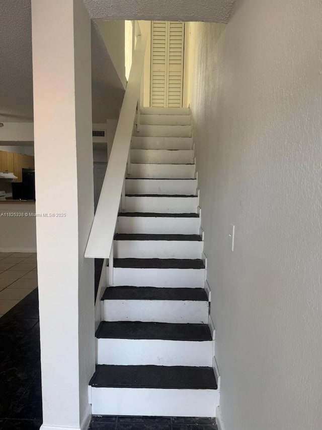 4045 NW 19th St, Lauderhill, FL 33313 - stairs featuring tile patterned flooring and a textured ceiling