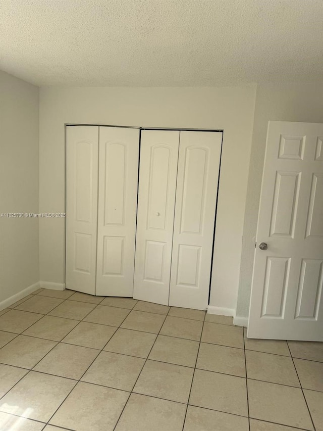 4045 NW 19th St, Lauderhill, FL 33313 - unfurnished bedroom with light tile patterned flooring, a closet, and a textured ceiling