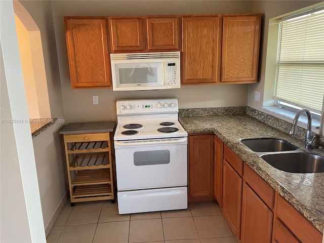 8325 Sunrise Lakes Blvd Unit 305, Sunrise, FL 33322 - kitchen with white appliances, light tile patterned floors, arched walkways, and brown cabinets