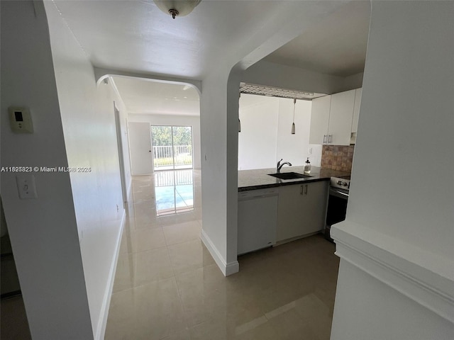 16465 NE 22nd Ave Unit 417, North Miami Beach, FL 33160 - kitchen with white dishwasher, dark countertops, decorative backsplash, range, and light tile patterned flooring