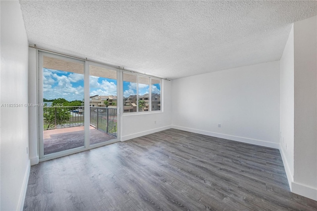 10700 SW 108th Ave Unit C316, Miami, FL 33176 - spare room featuring a textured ceiling, wood finished floors, and a wall of windows