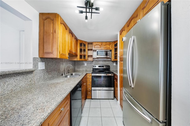10700 SW 108th Ave Unit C316, Miami, FL 33176 - kitchen with appliances with stainless steel finishes, brown cabinetry, light stone countertops, backsplash, and light tile patterned flooring