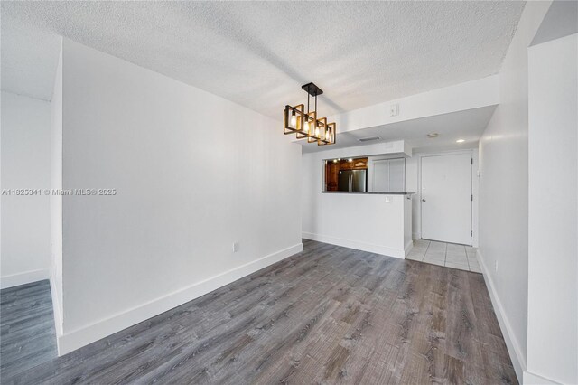 10700 SW 108th Ave Unit C316, Miami, FL 33176 - unfurnished living room with wood finished floors, a textured ceiling, and a chandelier